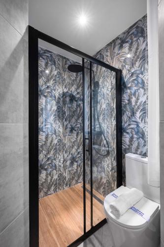 a bathroom with a toilet and a wall at Homevision - Architectural Condo in Thessaloniki