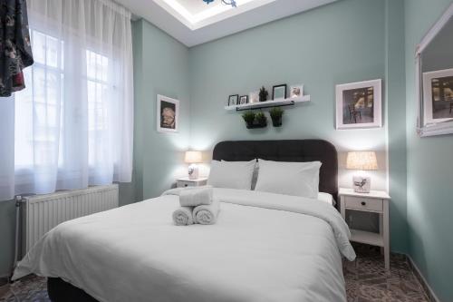 a bedroom with a white bed and a window at Homevision - Architectural Condo in Thessaloniki