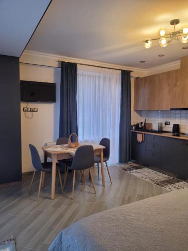 a dining room table and chairs in a room at Eco Village Apartments 4 with terrace in Bakuriani