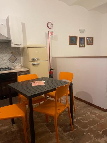 a kitchen with a table and chairs and a refrigerator at Il Sementone in Assisi