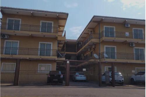 a building with cars parked in front of it at Apartamento Cedros- Excelente localização! in Corumbá