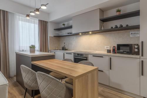una cucina con tavolo e sedie in legno di Modern Muse Apartment a Oradea