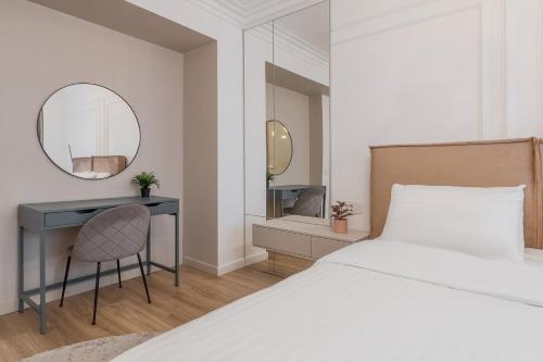 una camera da letto con un letto, una scrivania e uno specchio di Modern Muse Apartment a Oradea