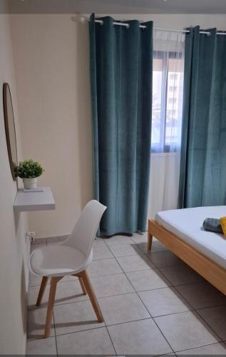 a bedroom with a chair and a bed and a window at By The Way Apartment 1 in Larnaka