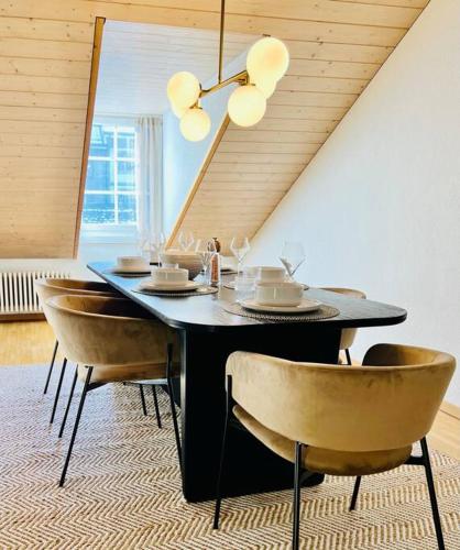 a dining room with a black table and chairs at Hidden Retreats The GreenAlley in Bern