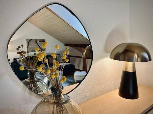 a mirror on a table with vases and a lamp at Hidden Retreats The GreenAlley in Bern