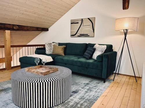a living room with a green couch and a table at Hidden Retreats The GreenAlley in Bern