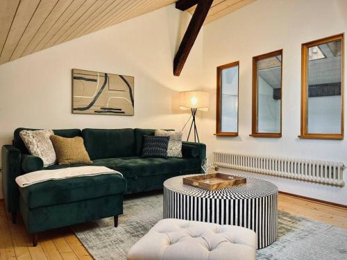 a living room with a green couch and a table at Hidden Retreats The GreenAlley in Bern
