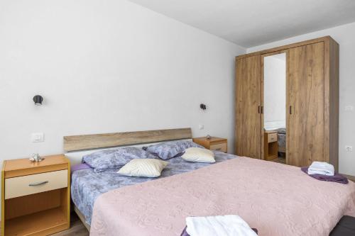 a bedroom with two beds and a wooden cabinet at Apartment Ivana with Sea View - Pet Friendly in Fažana