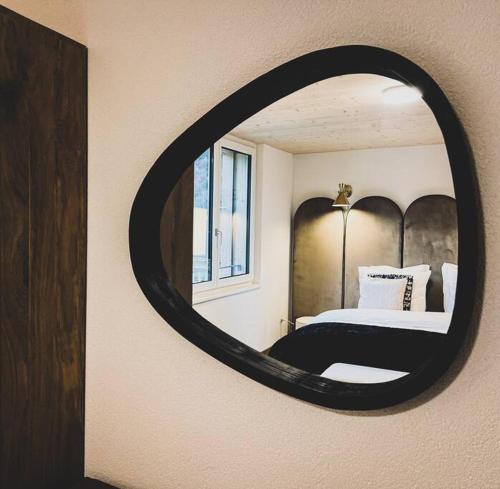 a bedroom with a bed and a round mirror at Hidden Retreats The Lohner in Reichenbach