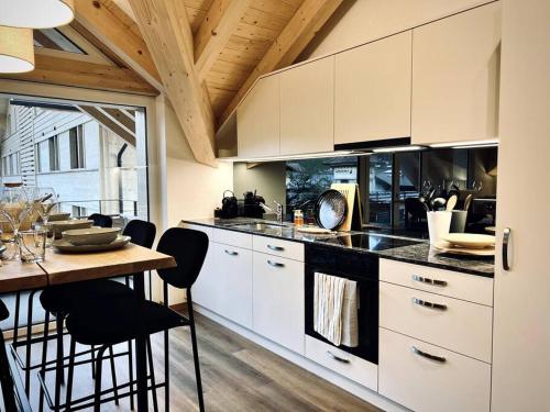 a kitchen with white cabinets and a table with chairs at Hidden Retreats The Lohner in Reichenbach