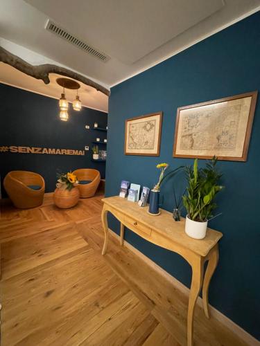 a room with a wooden table and a blue wall at Isolotto Guest House in Porto Ercole