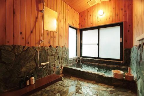a large bathroom with a tub and a window at Yufuin Waon no Yado - Vacation STAY 18114 in Yufu