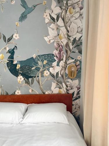 Un dormitorio con un mural de pared de flores y pájaros. en Ella Lux Apartment, en Skopje