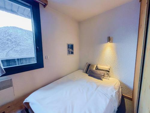 une petite chambre avec un lit et une fenêtre dans l'établissement Appartement Cozy pour 5 aux Menuires avec vue montagne - FR-1-452-93, aux Menuires