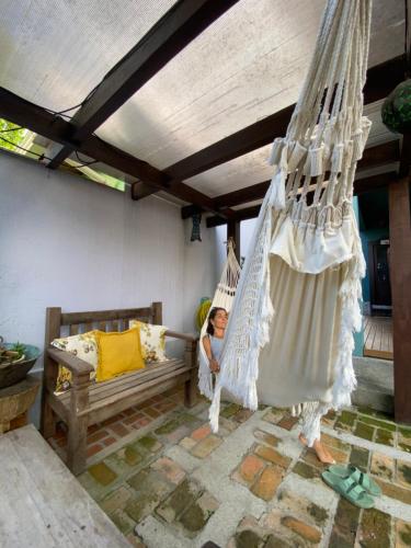 a young child sitting in a hammock in a porch at Solar das Pétalas Guest House in Florianópolis