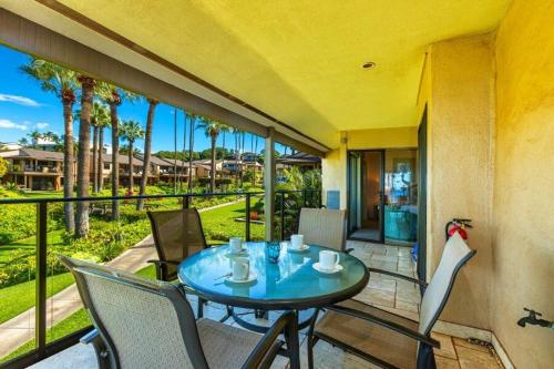a table and chairs on a balcony with palm trees at WAILEA ELUA, #1302 condo in Wailea