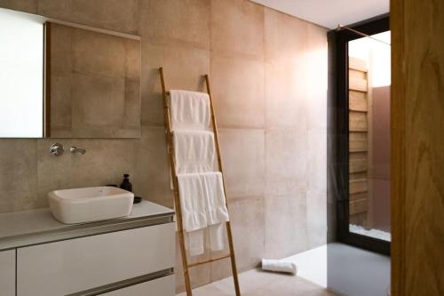 a bathroom with a white sink and a mirror at Souto Village - by MET - Private Pool & Lemon Farm in Paços de Gaiolo