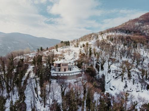 an aerial view of a house on a snowy mountain at A Dream Deferred villa Pelion in Kissós