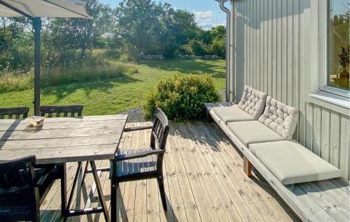 a wooden deck with a table and chairs and an umbrella at Gorgeous Home In Köpingsvik With Wifi in Köpingsvik