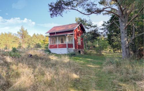 a red and white house in the middle of a field at 1 Bedroom Cozy Home In Vikbolandet in Arkösund
