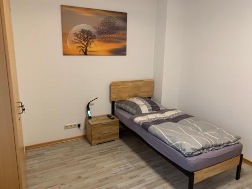 a small bedroom with a bed and a night stand at Monteurhaus, Monteurzimmer, Ferienwohnung in Löhnberg