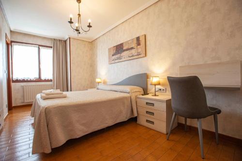a bedroom with a bed and a desk and a chair at CASA RURAL BARAZAR in San Sebastián