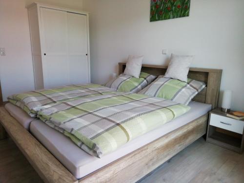 a bedroom with a large bed with a wooden frame at Ponyhof Adam Urlaub auf dem Bauernhof in Eschlkam