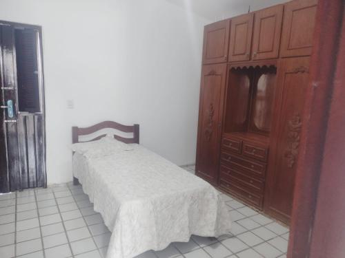 a bedroom with a bed and a wooden dresser at Casa Beira Mar Tabatinga in Nísia Floresta