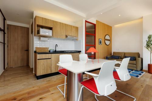 a kitchen and living room with a table and chairs at Casa Colon in Mexico City