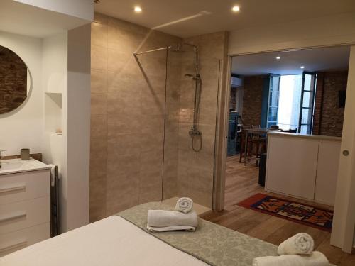 a bathroom with a shower with towels on a bed at Old Side Girona One in Girona