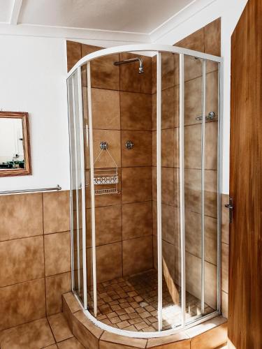 a shower with a glass enclosure in a bathroom at Lekkerbly Self Catering in Pofadder