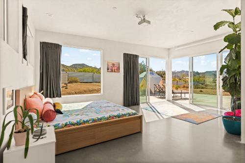 a bedroom with a bed and a large window at Beyond - Walk to Red Dog & Pappy's in Pioneertown