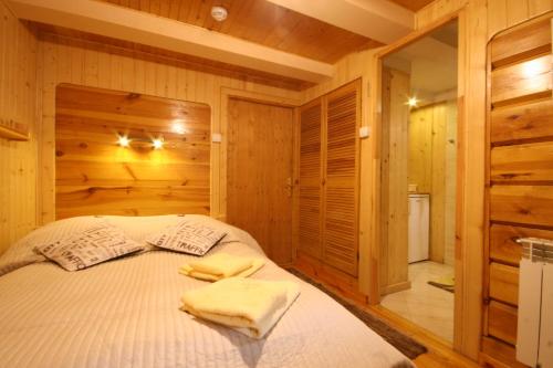 a bedroom with a bed with wooden walls and wooden floors at Willa Dewajtis in Zakopane