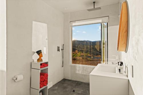 a white bathroom with a sink and a window at Beyond - Walk to Red Dog & Pappy's in Pioneertown