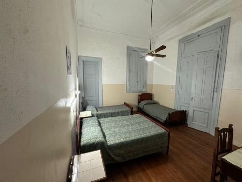 a room with two beds and a ceiling fan at Recoleta 680 in Buenos Aires
