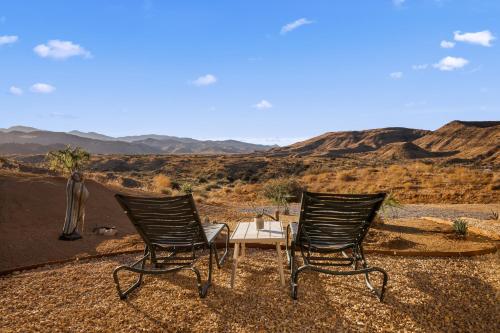 two chairs and a table in the middle of the desert at Beyond - Walk to Red Dog & Pappy's in Pioneertown