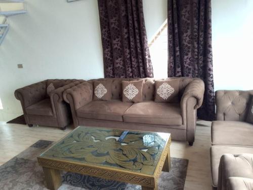 a living room with a couch and a coffee table at AK Homes in Rāwāt