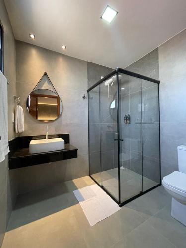 a bathroom with a glass shower and a sink at Luster Hotel in João Câmara