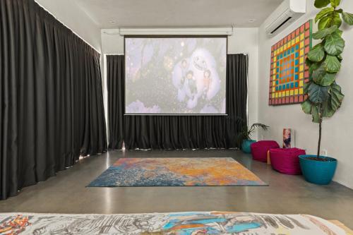 a living room with a large screen and a rug at Beyond - Walk to Red Dog & Pappy's in Pioneertown