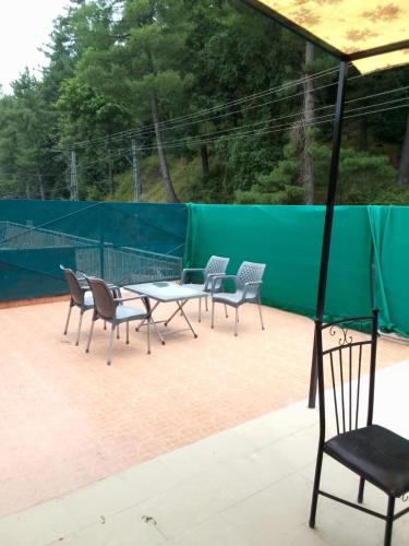 a group of chairs and a table on a tennis court at AK Homes in Rāwāt