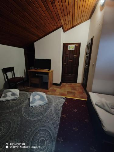 a bedroom with a bed and a desk with a computer at Парк - Хотел Макензен in Melnik