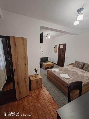a bedroom with a bed and a living room at Парк - Хотел Макензен in Melnik