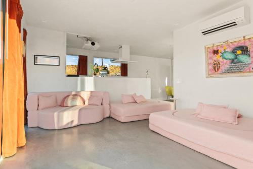 a pink living room with two pink chairs and a couch at Beyond - Walk to Red Dog & Pappy's in Pioneertown