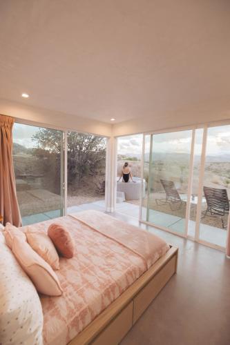 a bedroom with a large bed in front of a window at Beyond - Walk to Red Dog & Pappy's in Pioneertown