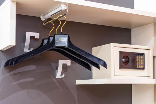 a black bat hanging from a wall next to a lightswitch at Hotel Demo' in Milan
