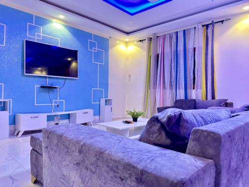 a living room with a couch and a tv at Yoda home in Saint-Louis