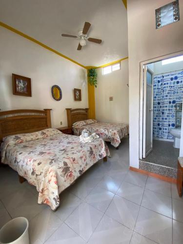 a bedroom with two beds and a bathroom at Hotel Colonial in Yautepec