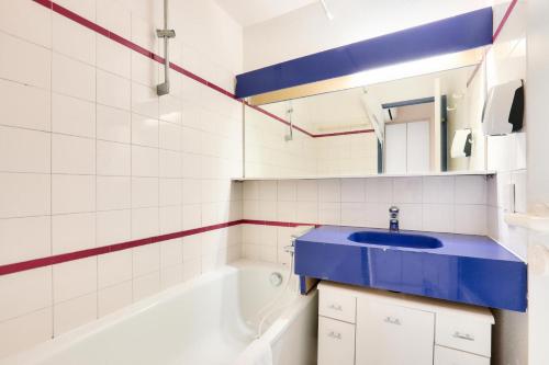 La salle de bains est pourvue d'un lavabo bleu et d'une baignoire. dans l'établissement Résidence Cannes Verrerie - maeva Home - Appartement 3 pièces 4 personnes - Budget MAE-6894, à Cannes