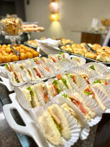 a bunch of sandwiches in paper plates on a table at Maximus Sottile Hotel in Ji-Paraná
